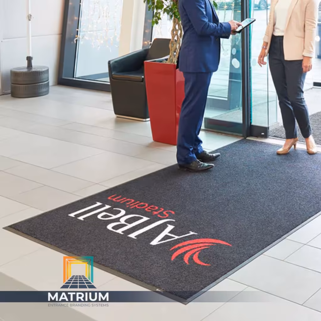 Custom branded AJ Bell Stadium entrance mat installed in a modern office lobby by Matrium.