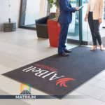 Custom branded AJ Bell Stadium entrance mat installed in a modern office lobby by Matrium.